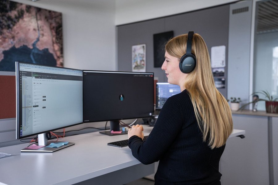 Developerin Lisa bei der Arbeit vor den Bildschirmen