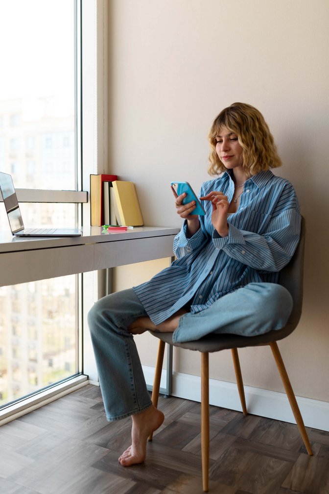 Frau hält Handy in der Hand und schaut darauf