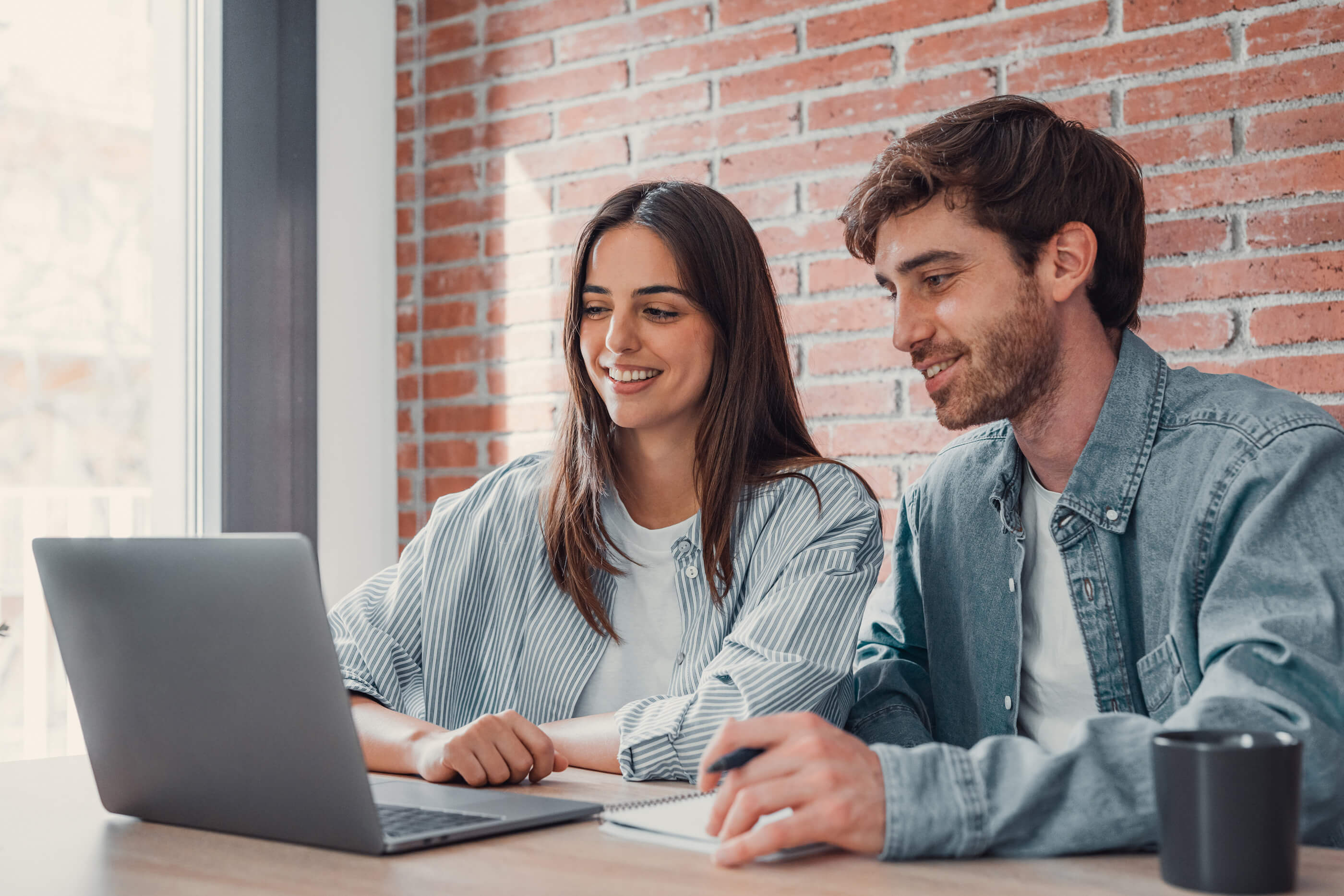 Frau und Mann vor dem Laptop bei einer Planung